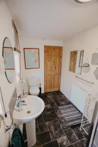 a bathroom with a white sink and a toilet at Unique, cosy, Lake District artist hideaway - 5 bd in Millom +45 photos