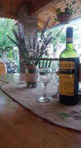 una botella de vino y dos copas de vino en una mesa en Rita Apartman & Studio, en Zrenjanin