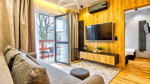 un soggiorno con divano e TV a schermo piatto di Apartament Wood Lux - 5D Apartamenty a Świeradów-Zdrój