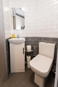 a bathroom with a white toilet and a sink at Newton Apartment nr Wigan Hospital in Wigan +6 photos