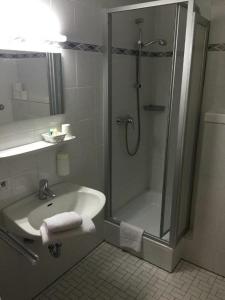 een badkamer met een douche en een wastafel bij Hotel Bad Driburg in Bad Driburg