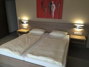 a large bed with two pillows on top of it at Hotel Bad Driburg in Bad Driburg
