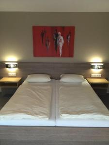 1 cama blanca grande con 2 almohadas y 2 luces en Hotel Bad Driburg, en Bad Driburg