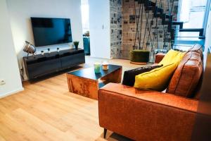 salon z kanapą i telewizorem w obiekcie Amazon Corten w mieście Marche-en-Famenne