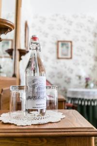 a bottle of alcohol sitting on a table with two glasses at The Inn at the Babcock House in Appomattox