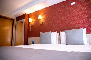 a bedroom with a white bed with a red wall at Cancún Hotel by H Hotéis - Airport in Brasilia