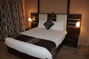 a bedroom with a large bed with white sheets and pillows at Airport Landing Hotel in Nairobi