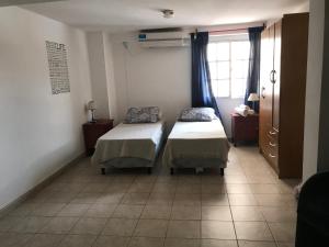 a room with two beds and a window at Belgrano 10 in Salta