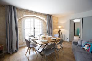 een woonkamer met een tafel en een bank bij Place du Palais in Bordeaux