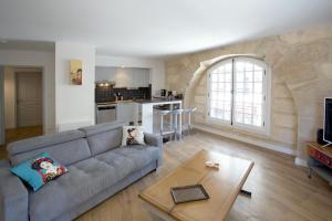 een woonkamer met een bank en een tafel bij Place du Palais in Bordeaux