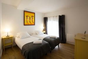 1 dormitorio con 2 camas y una ventana con una pintura en Place du Palais, en Burdeos