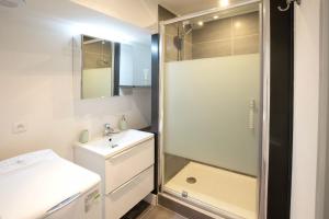 Un baño con ducha, lavabo y espejo. en Place du Palais, en Burdeos 7 fotos más