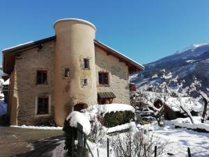 a building with a chimney covered in snow at A la Bouge'Hôtes in Bellentre
