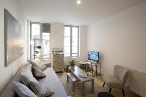 - un salon avec un canapé et une télévision dans l'établissement Centre historique - Le Maubec, à Bordeaux