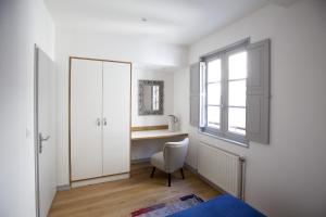 - une chambre avec un bureau, une chaise et un miroir dans l'établissement Centre historique - Le Maubec, à Bordeaux