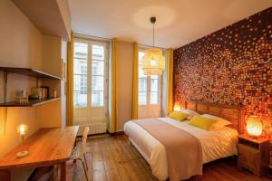 ein Schlafzimmer mit einem großen Bett und einem Holztisch in der Unterkunft Appartement Luxe - La Devise in Bordeaux