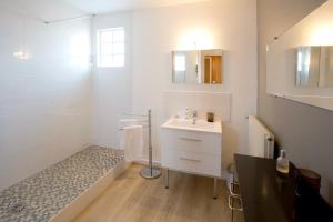 uma casa de banho branca com um lavatório e um chuveiro em Appartement 2 chambres Chartrons em Bordeaux