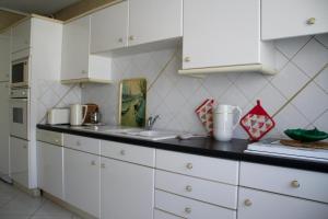 a kitchen with white cabinets and a black counter top at Appartement 2 chambres Chartrons in Bordeaux