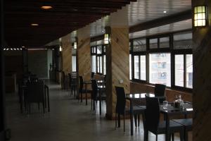 a dining room with tables and chairs and windows at Airport Landing Hotel in Nairobi