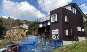 ein Haus mit einem blauen Zaun davor in der Unterkunft Kamogawa - House - Vacation STAY 9979 in Kamogawa