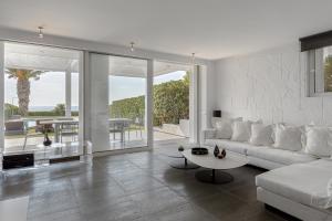 a living room with a white couch and a table at Luxurious Beachfront Villa Maira in Aghia Marina +58 photos