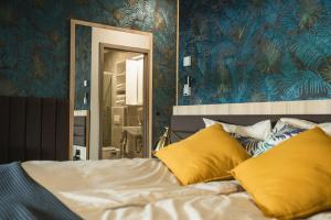 - une chambre avec un lit doté d'oreillers jaunes et d'un miroir dans l'établissement B&B La Siesta, à Markovci