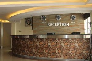 a reception counter in a hotel lobby with a stone wall at Airport Landing Hotel in Nairobi