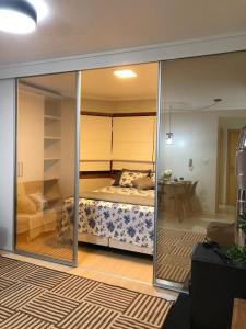 a bedroom with a bed through a glass wall at Apartamento Borges Gramado in Gramado