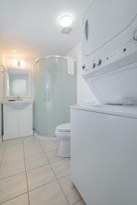a white bathroom with a toilet and a shower at 306 E Arctic Ave. in Folly Beach