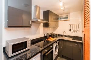 a kitchen with a sink and a microwave at 1 Bedroom Newton Apartment l Free Parking l Wigan Royal Infirmary l Haigh Hall l Central Location in Wigan