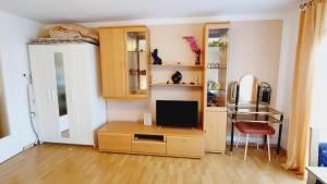 ein Wohnzimmer mit einem TV und einem Schreibtisch mit einem TV in der Unterkunft Gemütliche Wohnung in Langenargen in Langenargen