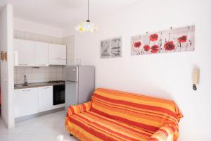 a kitchen with a refrigerator and an orange blanket at Appartamento Sole in San Vito lo Capo