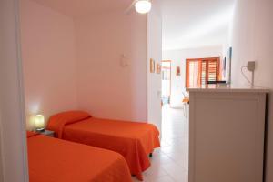 una camera d'albergo con due letti e un corridoio di Appartamento Sole a San Vito lo Capo