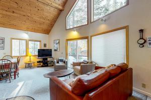 a living room with a brown leather couch and windows at Poma Lane in Soda Springs