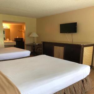 a hotel room with two beds and a flat screen tv at Altamonte Springs Hotel and Suites in Orlando