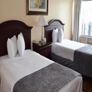 Habitación de hotel con 2 camas y ventana en Altamonte Springs Hotel and Suites en Orlando