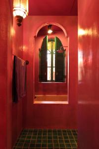 a red bathroom with a mirror and a window at A Fei Surf Inn III in Nanwan