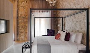 a bedroom with a large bed and a chair at Hotel Boutique Casa Zevallos in Córdoba