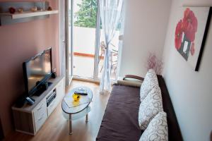 a living room with a couch and a tv and a table at Apartment Jovicevic in Kotor