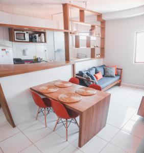 a kitchen and living room with a wooden table and chairs at Portal do Atlântico in Barra de São Miguel