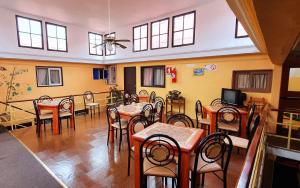ein Esszimmer mit Tischen und Stühlen sowie einem TV in der Unterkunft Hotel Iberia in Coquimbo