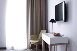 a room with a desk and a tv on a wall at BLEECKER Hotels in Belgrade