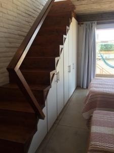 a staircase in a room with white cabinets and a window at Miralejos Complejo de Apartamentos in Punta Del Diablo