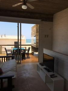 a living room with a fireplace and a table with chairs at Miralejos Complejo de Apartamentos in Punta Del Diablo