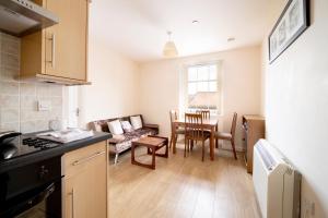 a kitchen and living room with a couch and a table at Becket apartment in Yeovil
