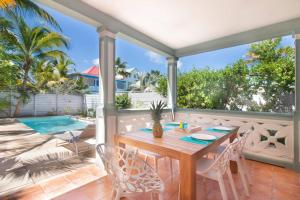 a patio with a table and chairs and a pool at Villa Aquamarine, 2 bedroom beach house and private pool, Orient beach! in Orient Bay