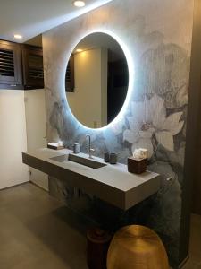 ein Bad mit einem Waschbecken und einem Spiegel in der Unterkunft Strandhotel Schmerikon in Schmerikon