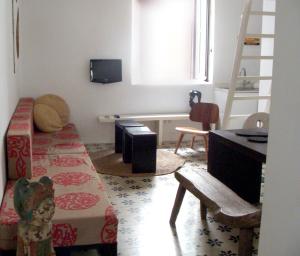 a living room with a desk and a bed and a desk at Apartamentos Casa del Coronel in Tarifa