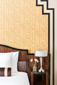 
a bed with a wooden headboard next to a wall at Walker Hotel Greenwich Village in New York
