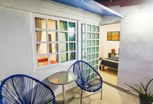 a room with two chairs and a table and a window at HominngBird Acapulco in Acapulco